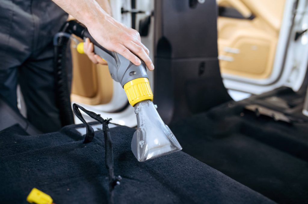 worker cleans car interior with vacuum cleaner 2021 08 29 10 13 46 utc 2